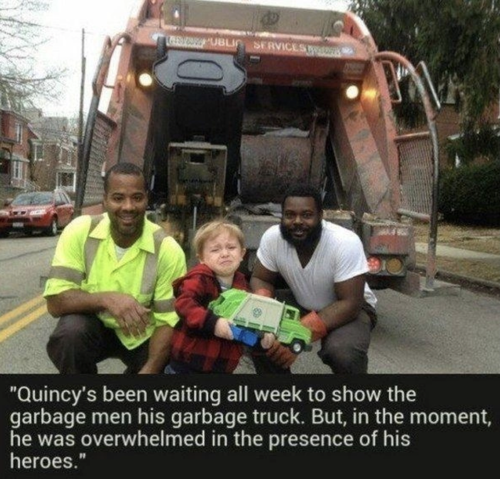 Cute picture of kid who was overwhelmed by meeting garbage men heroes. 