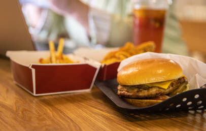 An image of a burger placed next to container of fries.