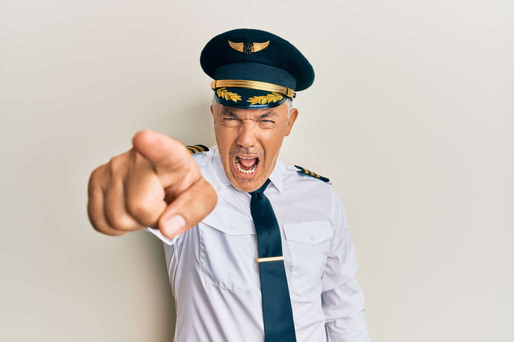 An angry male pilot pointing his finger at the camera. 