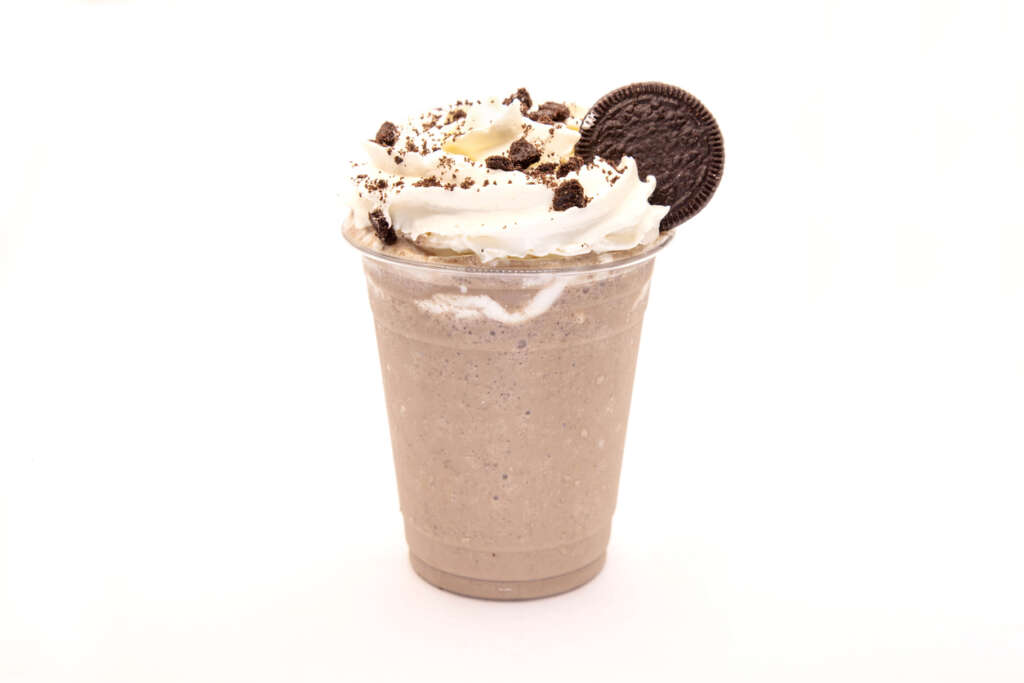 A large-sized milkshake with a cookie and whipped cream. 
