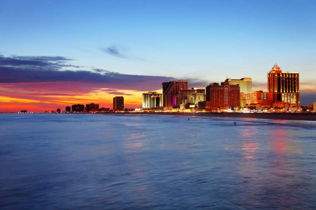 An image of Atlantic City at nighttime with a scene of the water. 