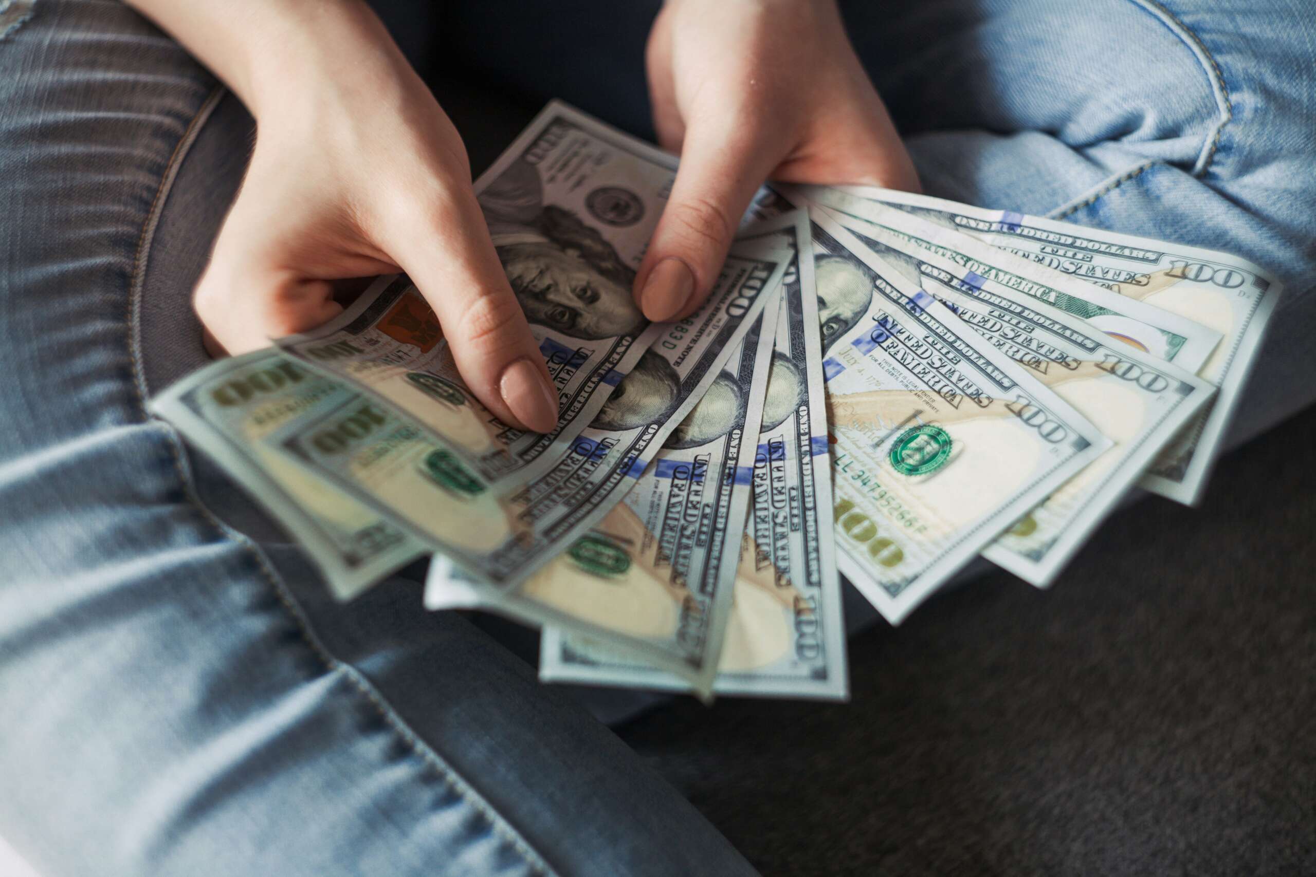 An image of a person holding up a pile of cash.