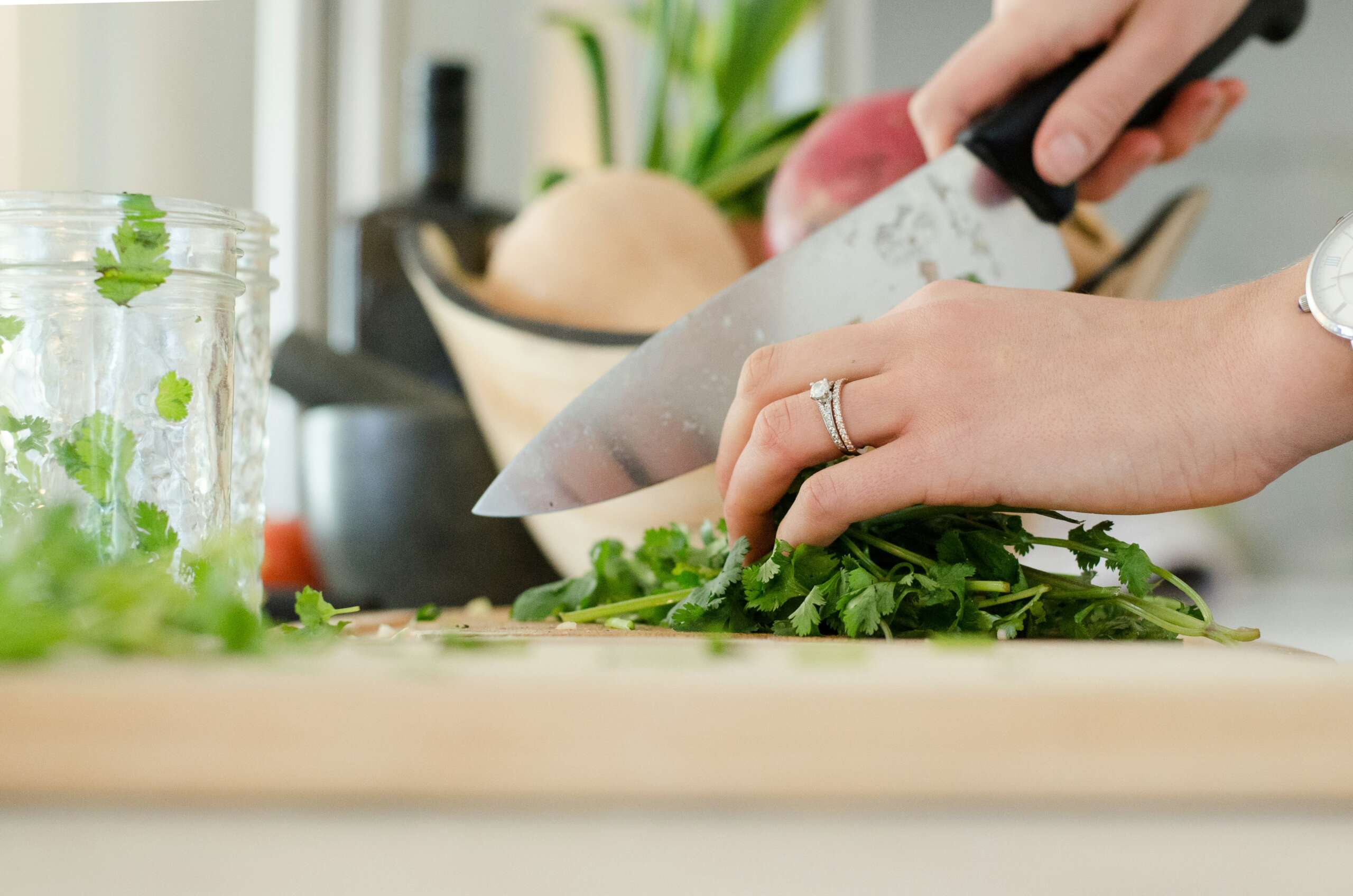 An image of someone cutting herbs with a chef's knife.