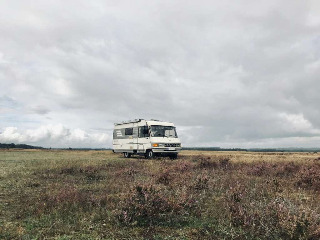 An image of an RV parked in grassy plains. 