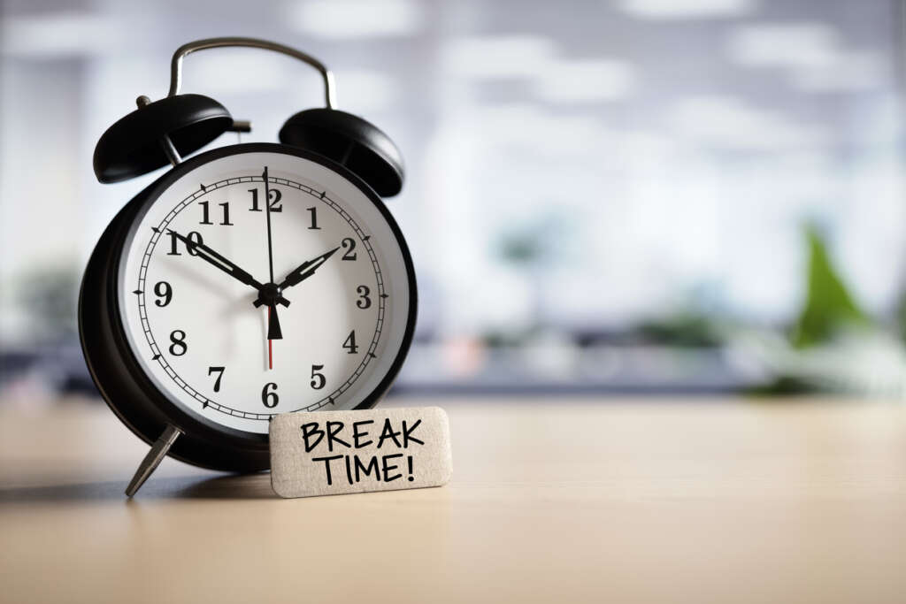An image of a clock placed behind a note saying "break time!"