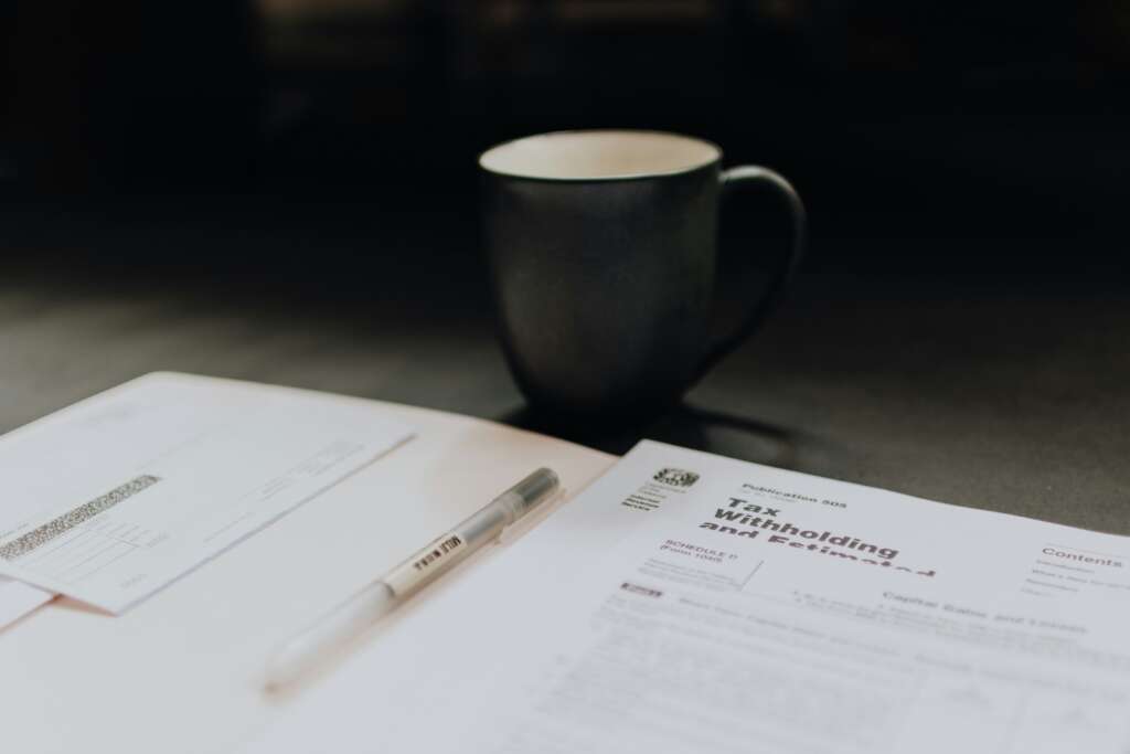 An image of a black coffee mug placed by a tax withholding document.