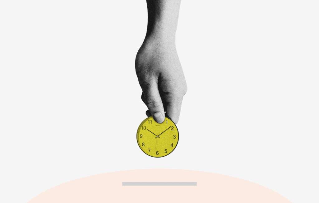 An image of a hand dropping a gold colored clock coin into a piggy bank. 