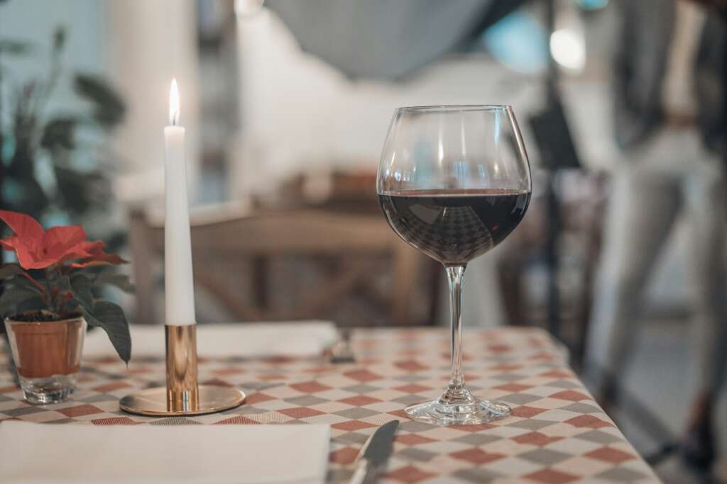 A glass of red wine placed on a nice table. 
