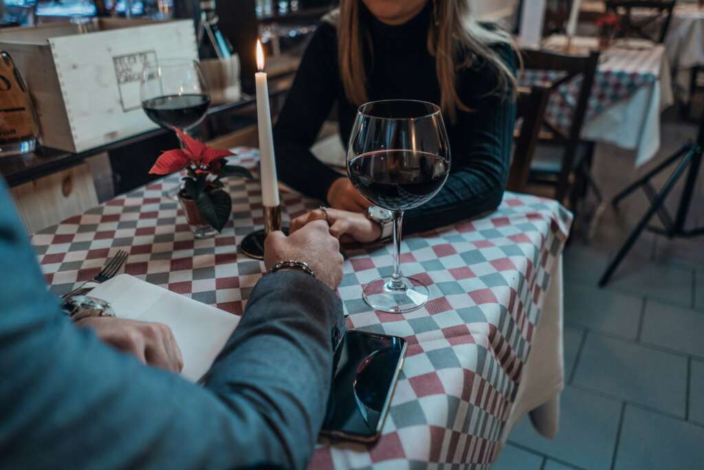 A couple holding hands while on a nice dinner date.