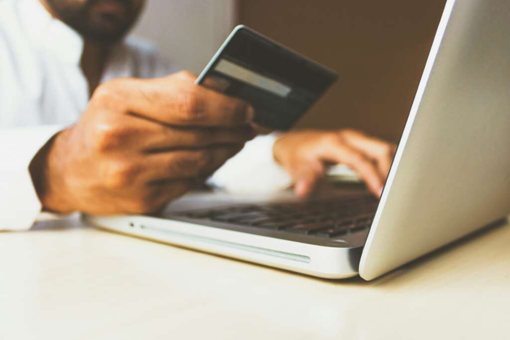 An image of a person checking their credit card on their laptop. 