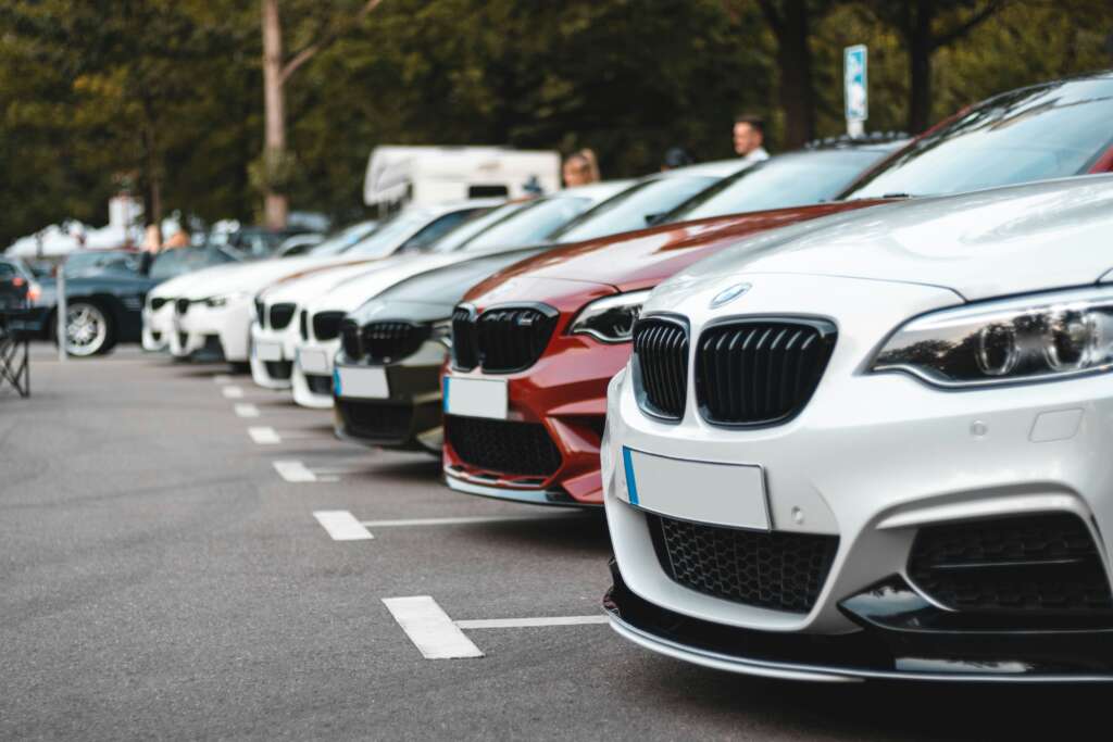 An image of numerous BMWs in a car lot. 