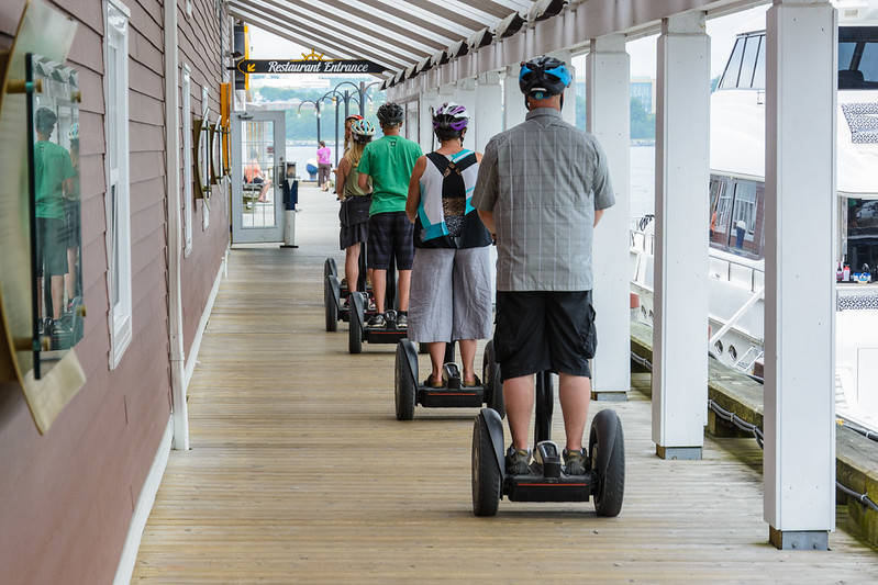 An image of a group of people using Segways outside. 