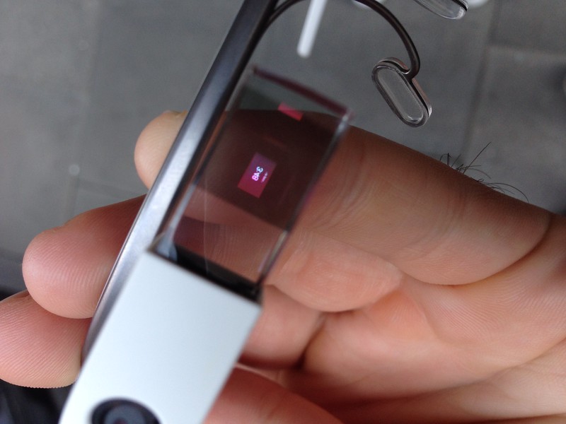 A close-up image of someone holding a Google Glass device. 