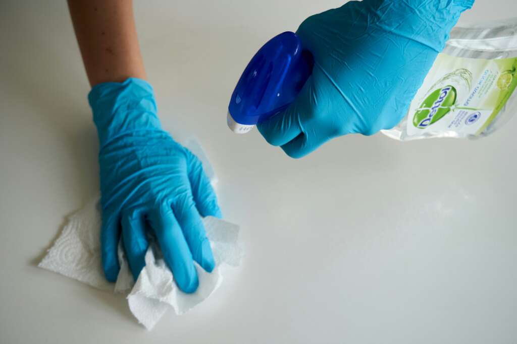 An image of someone wiping down a counter tip with a cleaning product. 