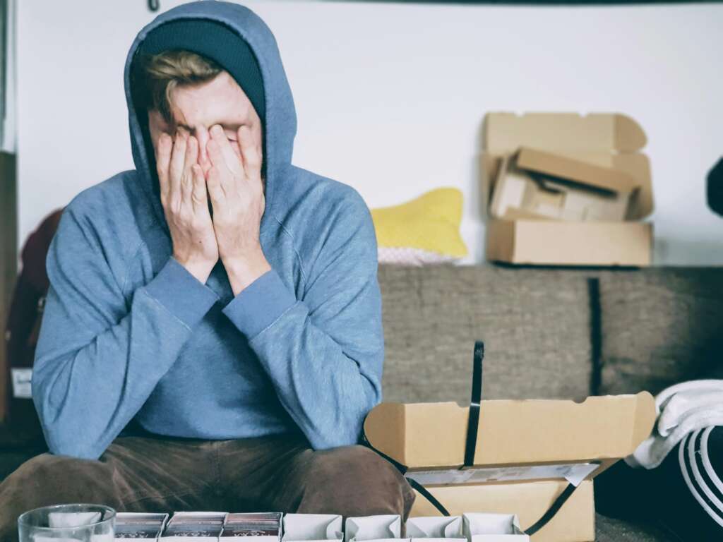 An image of a person who is very burned out while wearing a blue sweatshirt. 