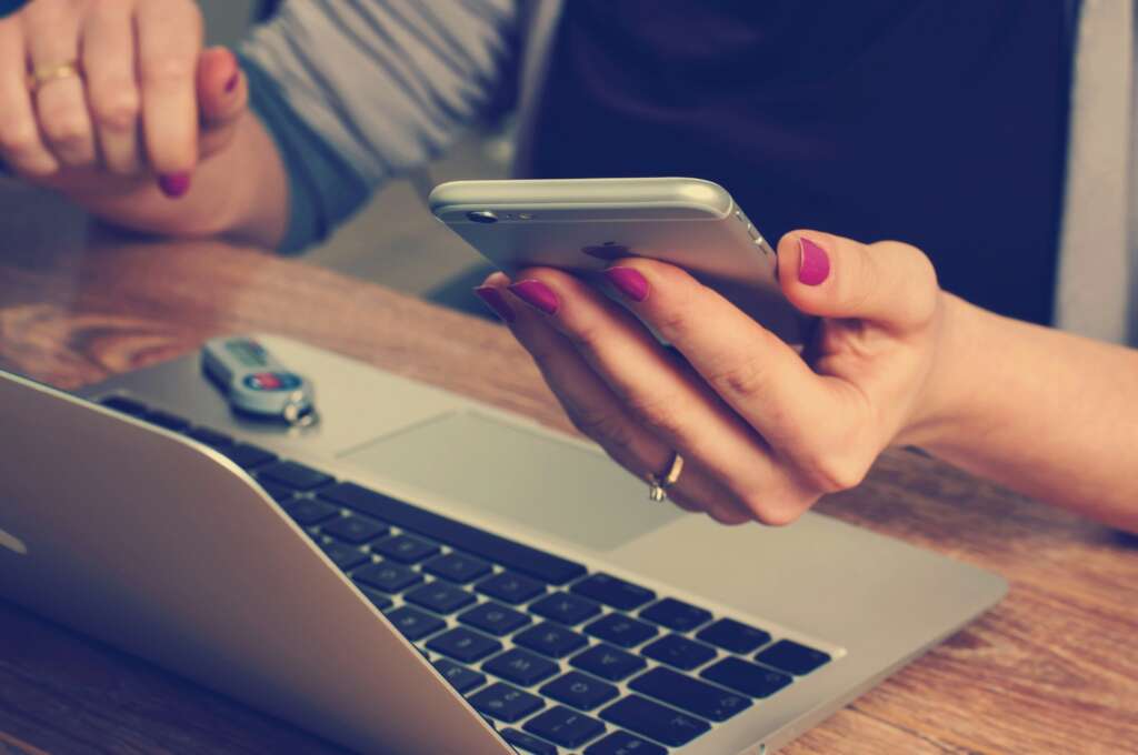 A person on their phone while using their laptop. 