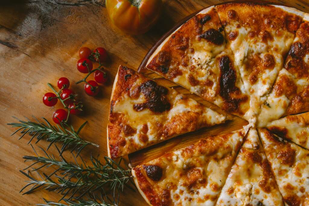 A wooden plate of pizza. 