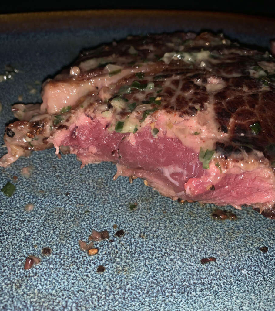 An image of a steak that was allegedly cooked medium-rare, yet looks nothing of the sort. 