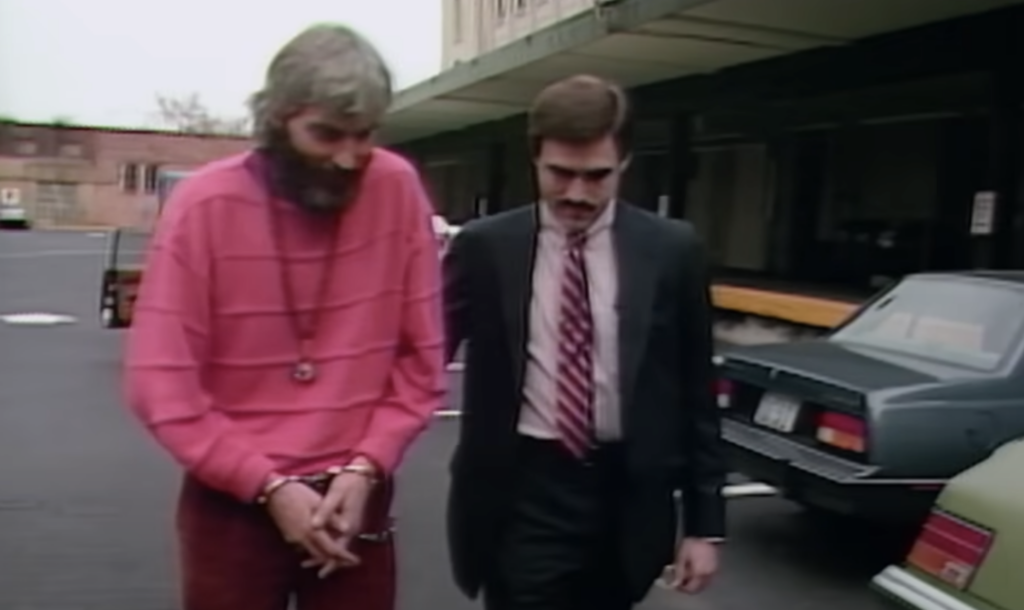 An image of a Rajneesh Movement follower being arrested. 