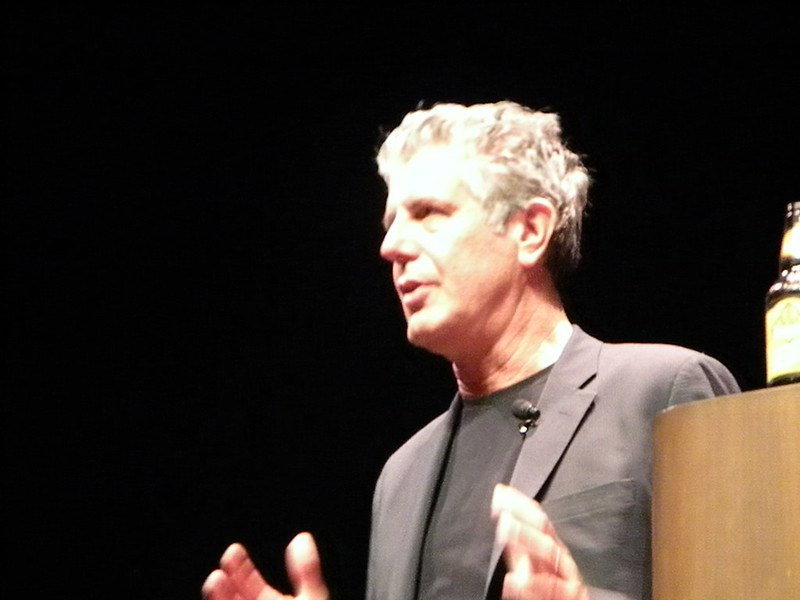 An image of Anthony Bourdain giving a speech. 