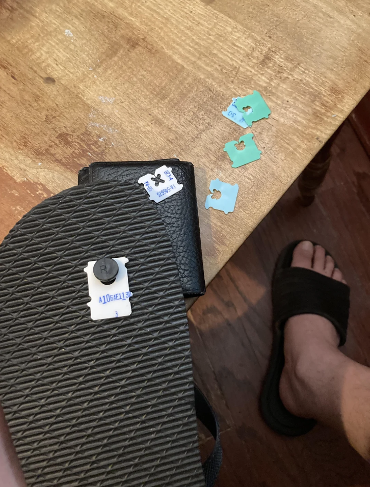 An image of someone who fixed their worn flip-flops with bread clips. 