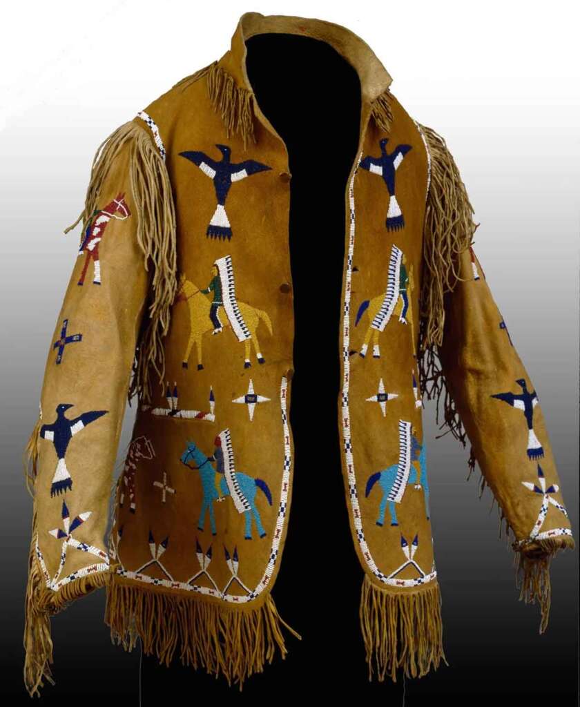 A detailed brown suede jacket adorned with intricate beadwork depicting birds, horses, and geometric patterns. The jacket features fringe accents on the sleeves and shoulders, creating a traditional and culturally rich appearance.