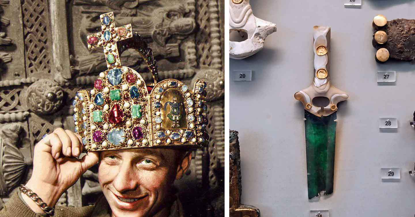 A man wearing a richly decorated, gem-studded crown adorned with various colored stones and a cross poses near an exhibit. Beside him, a display showcases an ornate ceremonial dagger with a green blade and jeweled hilt, accompanied by several numbered artifacts.