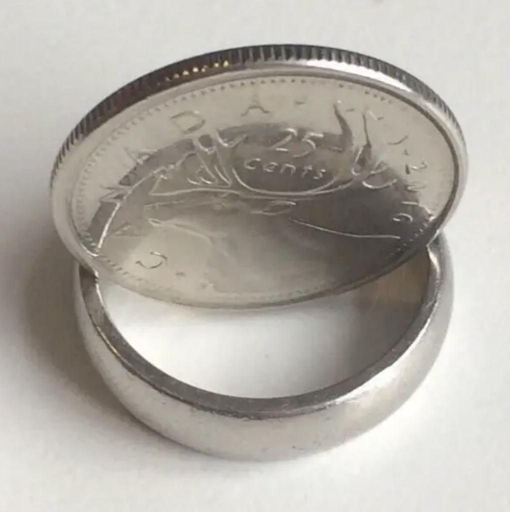 A coin that's been balanced on a ring so that the coin looks transparent. 