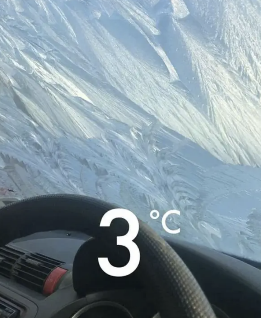 A frozen windshield that looks like a snowy mountain. 