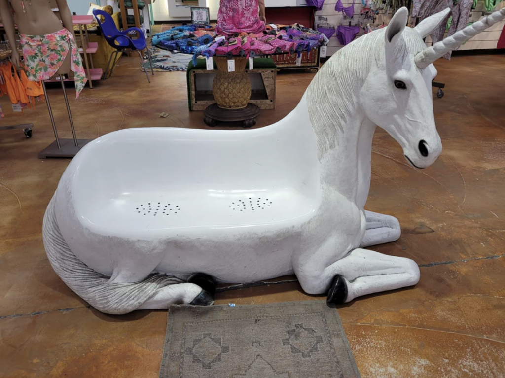 An image of a very creepy unicorn seat in a beach store. 