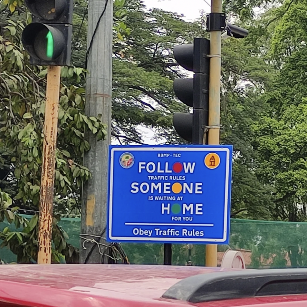 An image of a follow someone home sign on the road. 