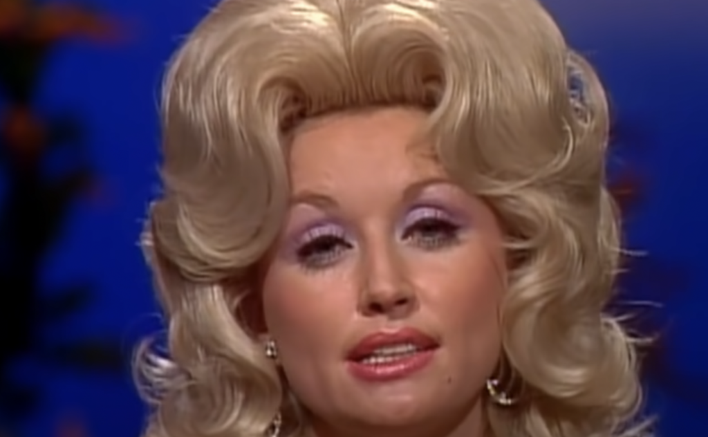 Young Dolly Parton staring into the camera. 