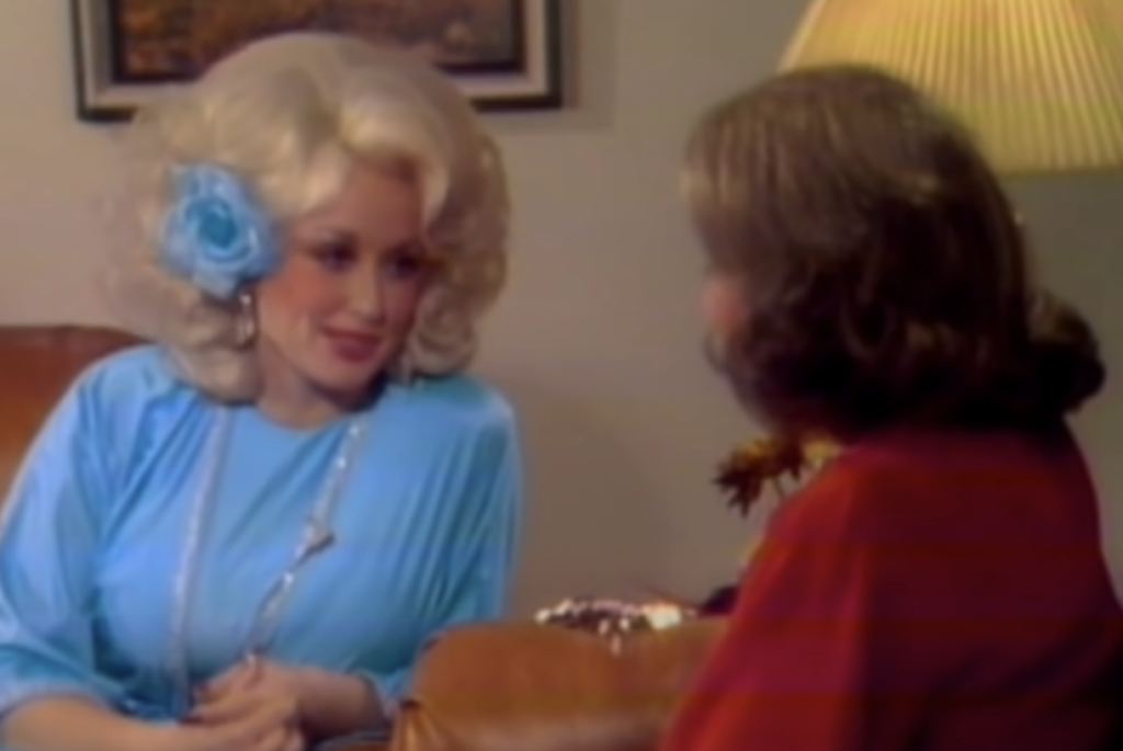 Young Dolly Parton being interviewed in a bright blue dress. 