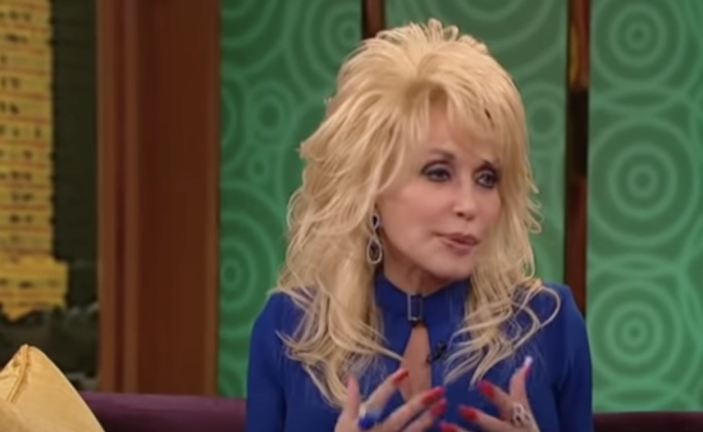 Dolly Parton being interviewed in a blue shirt. 