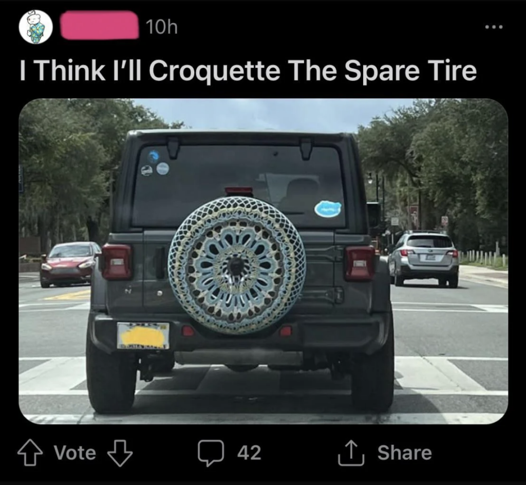 A social media post showing the rear of a parked Jeep with a crocheted tire cover on its spare tire. The caption humorously reads, "I Think I'll Croquette The Spare Tire." The interface shows options to vote, comment, and share, along with engagement stats.