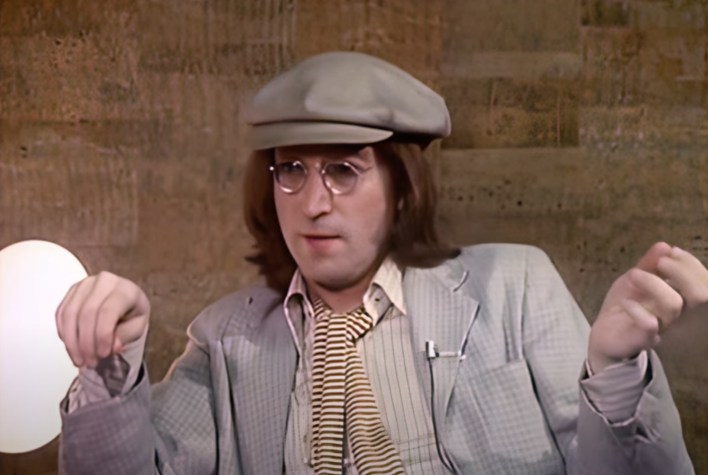 A close-up image of John Lennon being interviewed. 