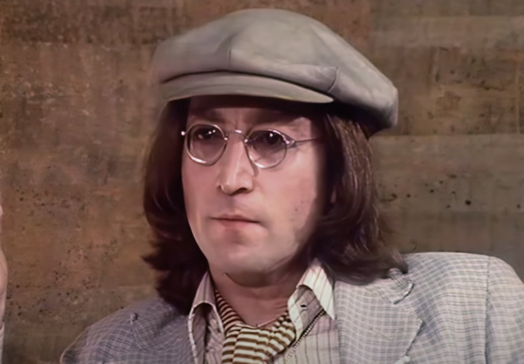 A close-up image of John Lennon being interviewed. 