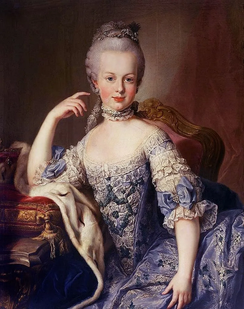 A classical portrait of a woman in 18th-century aristocratic attire. She's seated in an ornate chair, wearing an elaborate blue and white gown adorned with lace and ribbons. Her powdered hair is styled high, and she has a serene, composed expression.