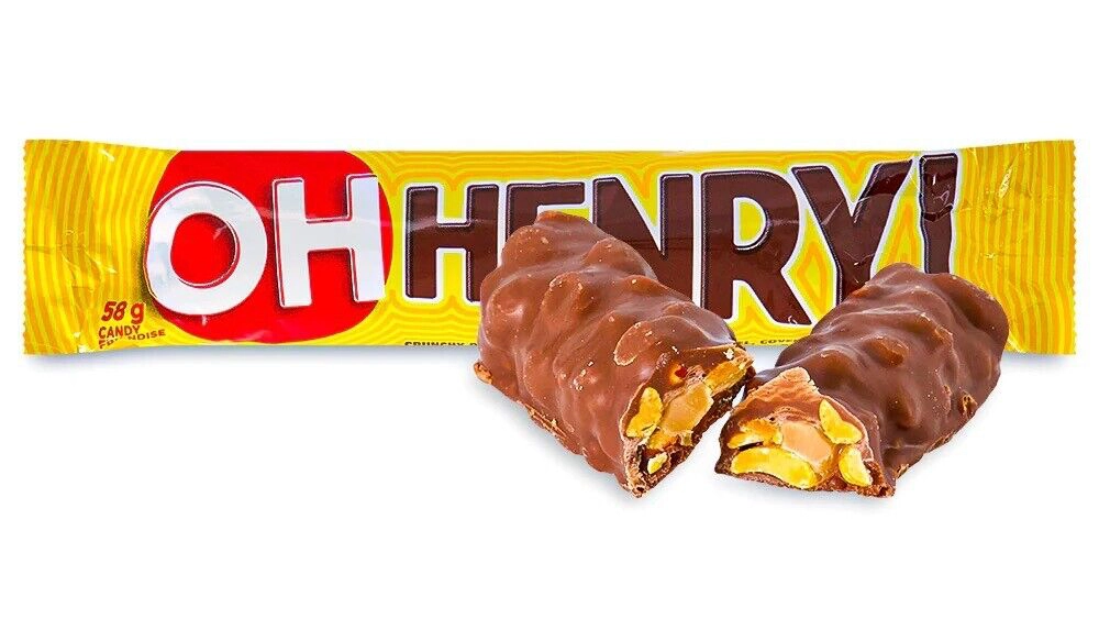 Image of a candy bar called "OH HENRY!" in yellow packaging. The candy bar is shown unwrapped with a piece cut to reveal its interior, which contains peanuts and caramel coated in chocolate. Text on the packaging indicates the weight as 58 grams.