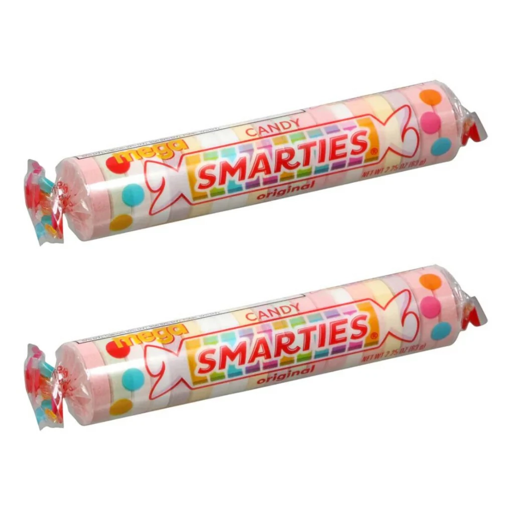 Two rolls of Mega Smarties candy are shown. The rolls are wrapped in transparent plastic with a colorful label that reads "Mega Smarties Candy Original" and includes colorful dots.