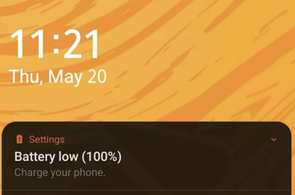 Someone receives an alert from their iPhone that their phone is at 100%. 
