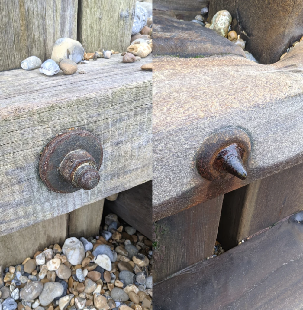 A side-by-side image of two different types of rusty bolts on a wooden structure. The left bolt displays a rounded, nut-secured end, while the right bolt has a sharp, pointed end. Pebbles and rocks are scattered around the base of the wood.