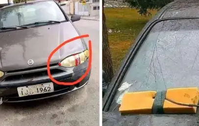 The image shows a car with two unusual features. On the left, one of its headlights is covered with packaging tape. On the right, a squeegee is wedged under the windshield wiper to serve as a replacement.