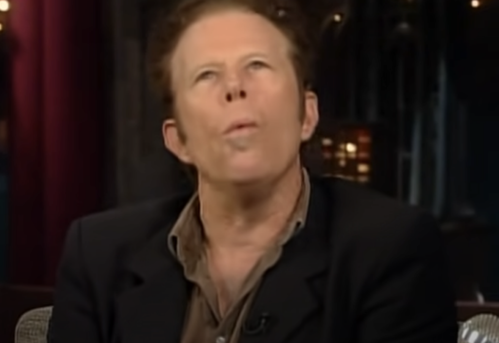 Tom Waits looking up while whistling. 