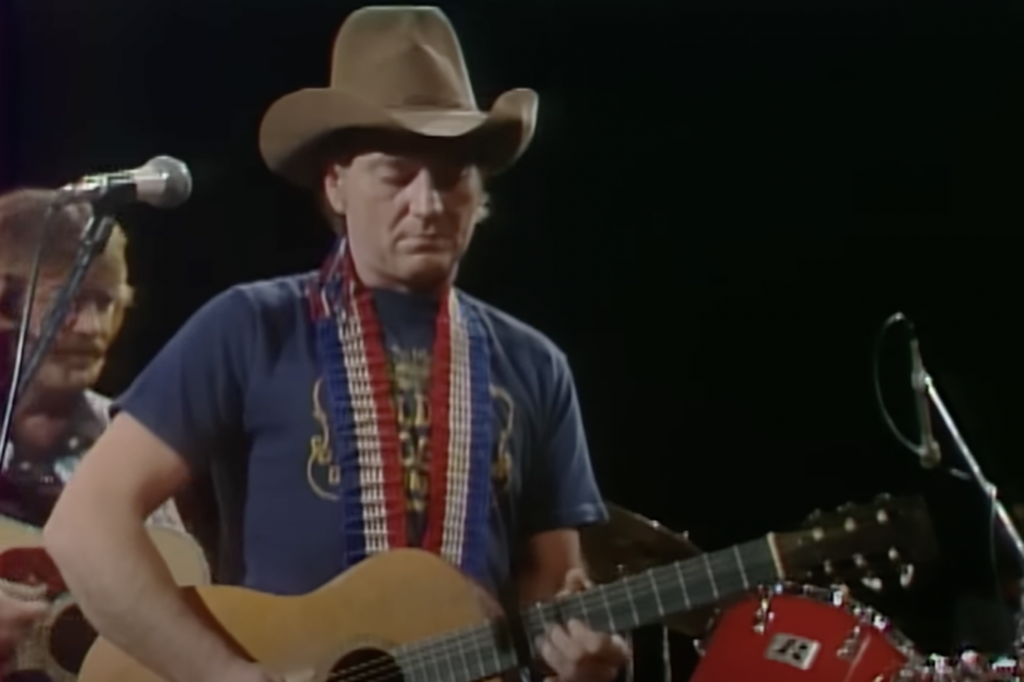 An image of Willie Nelson playing a concert. 