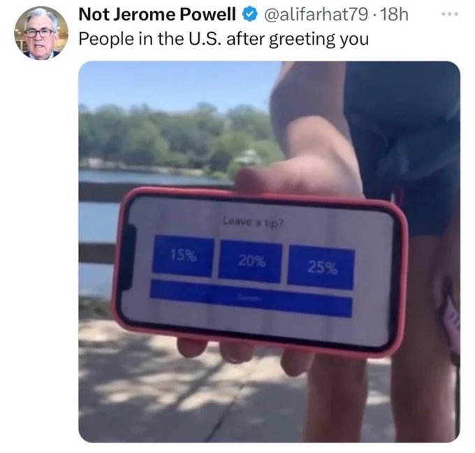 A person is holding a phone horizontally with a screen displaying tipping options of 15%, 20%, and 25%. The background shows an outdoor setting. The tweet above the image, from a user named "Not Jerome Powell," reads: "People in the U.S. after greeting you.