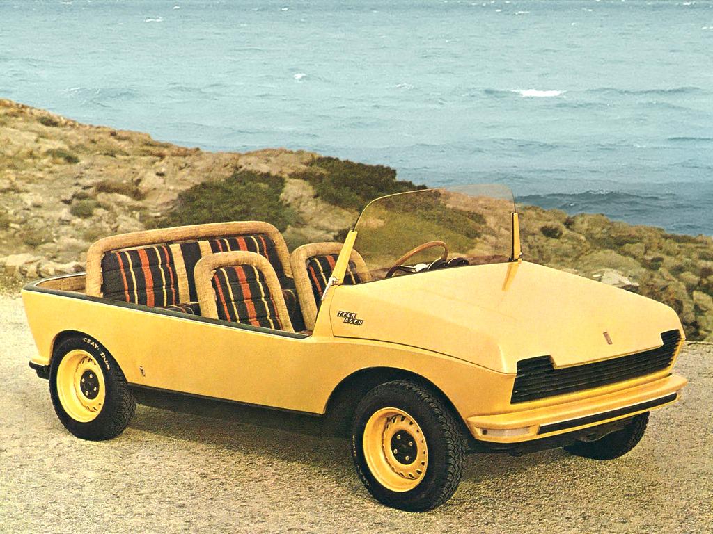 A yellow vintage convertible car with striped seats is parked on a rocky coastal area with the ocean in the background. The car has a minimalistic design with no roof or doors, and the scenery features a rough terrain with sparse vegetation.