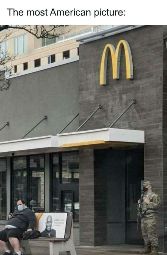 A photo of a McDonald's restaurant front with a large yellow 'M' sign on the facade. A man sits on a bench outside, wearing a mask. To the right, a person in military uniform stands with a rifle. Above, text reads "The most American picture:".