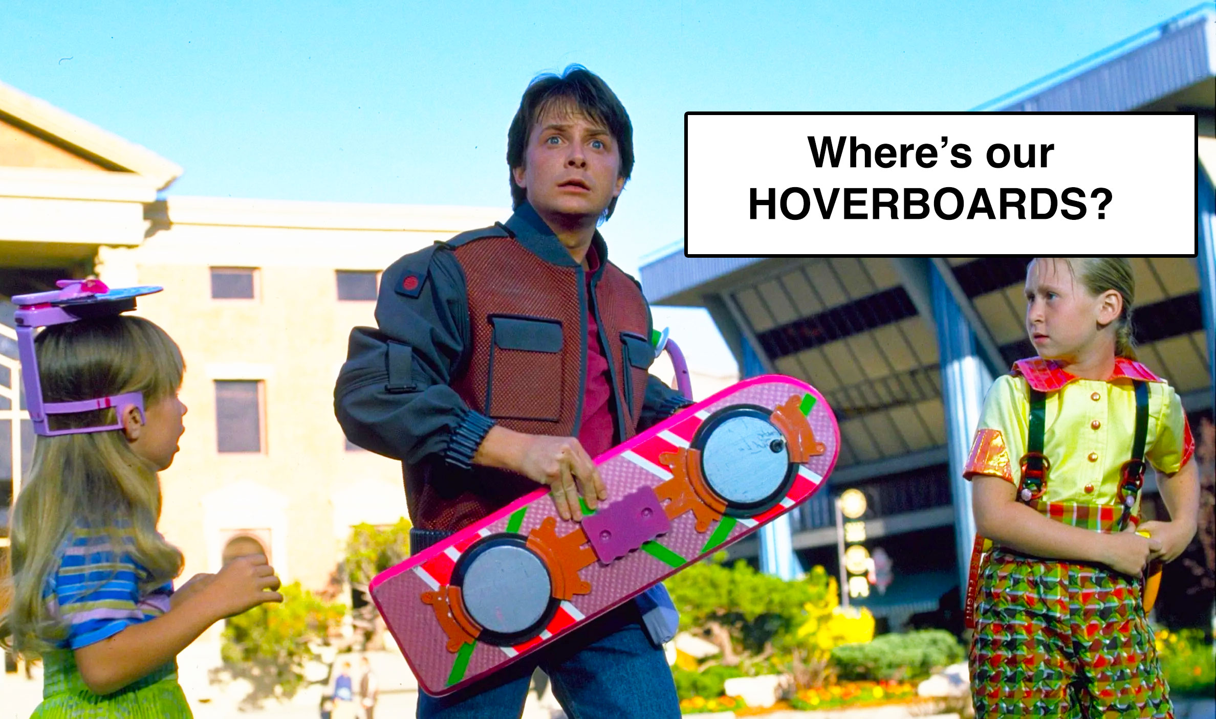 A person holding a pink hoverboard looks surprised or confused. To the left, a young child in a blue and pink outfit, and to the right, another child in a multicolored outfit. The text in the image says, "Where’s our HOVERBOARDS?" The background shows a modern building.