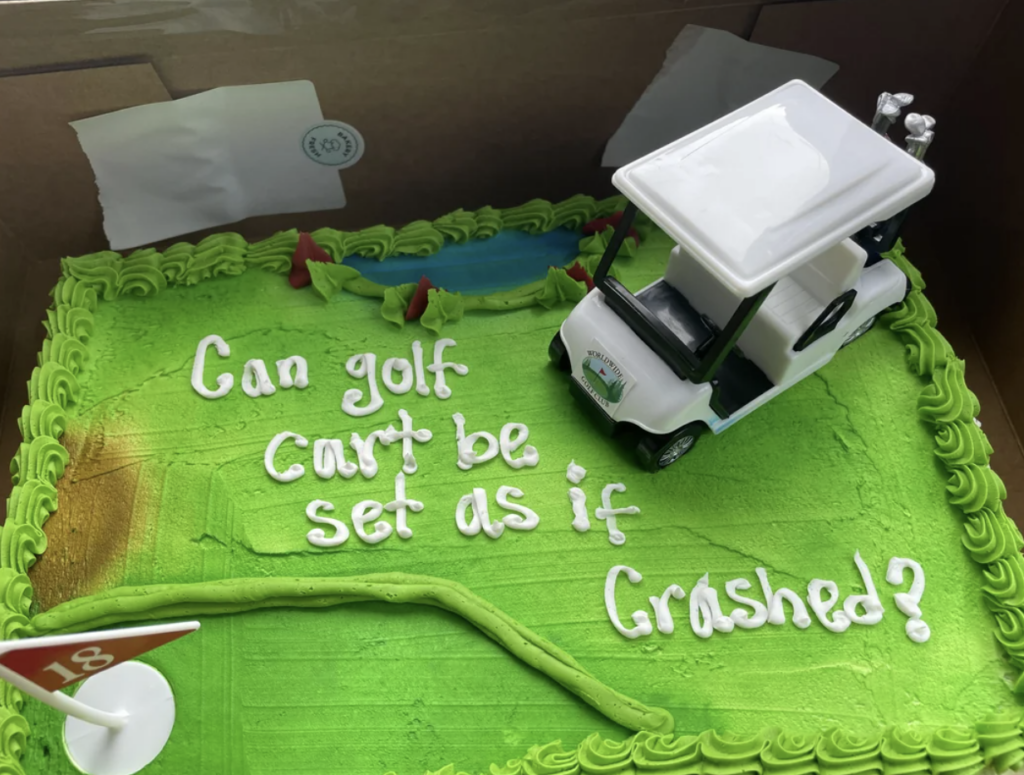 A rectangular cake with bright green frosting depicting a golf course. There is a small white toy golf cart placed off-road on the cake. The text on the cake reads, "Can golf cart be set as if crashed?" A small red flag with the number 18 is also on the cake.